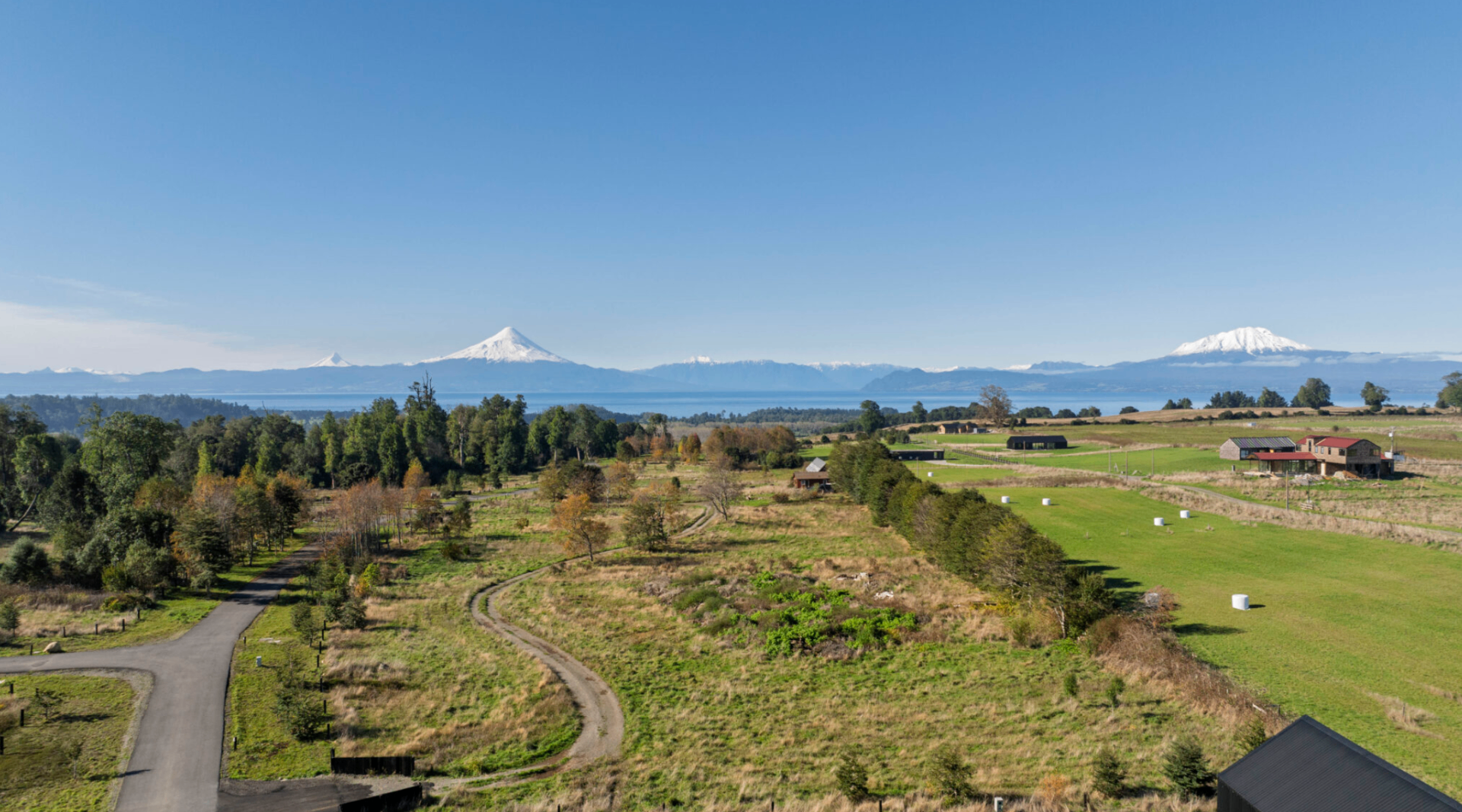 Vista panorámica de paisaje chileno con volcanes y lago